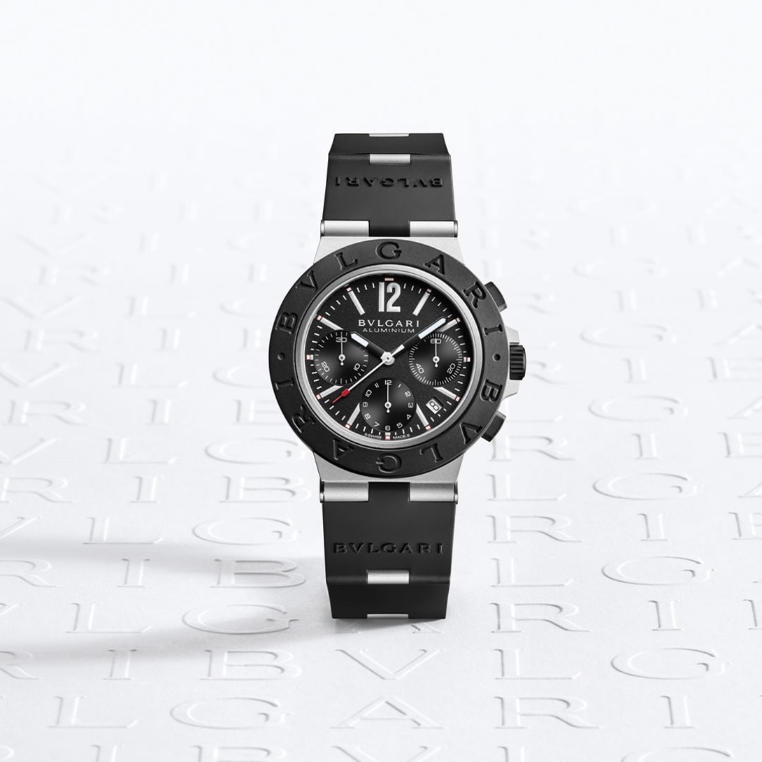 Bulgari Aluminium watch with chronograph, aluminum case, black rubber bracelet, logo backdrop.