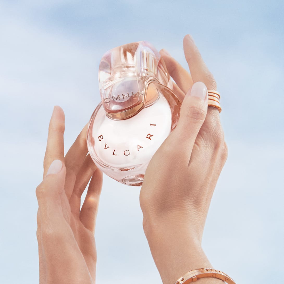 Powder pink transparent bottle of the Omnia Crystalline Eau de Parfum, blue sky in the background.