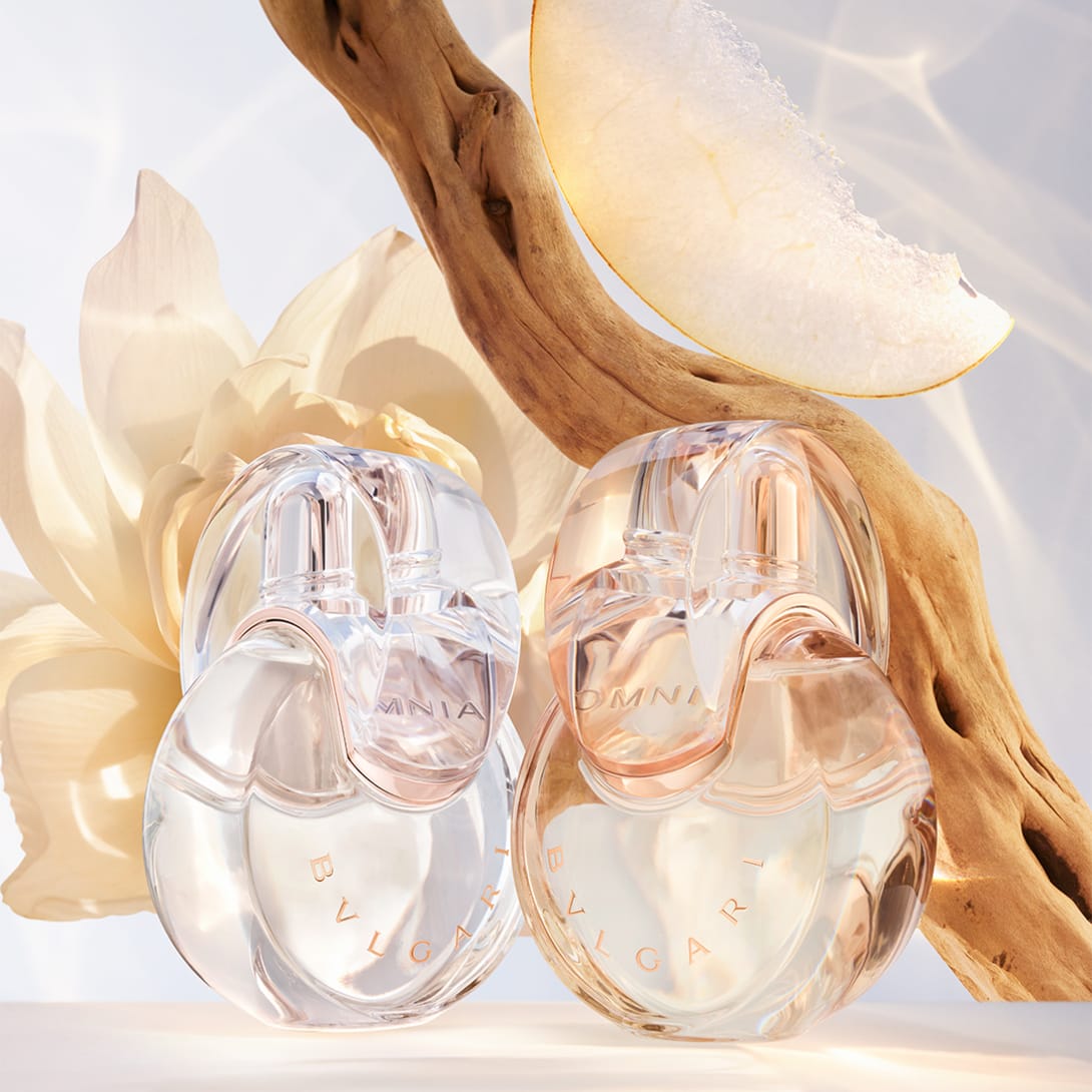 Omnia Crystalline, Omnia Amethyste and Omnia Coral fragrance bottles against a white, purple and red background.