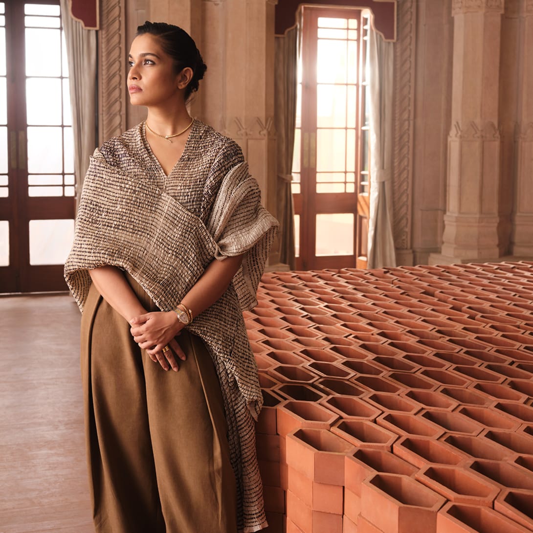 Indian artist Doyel Joshi beside her terracotta Passing The Light installation for Bvlgari.