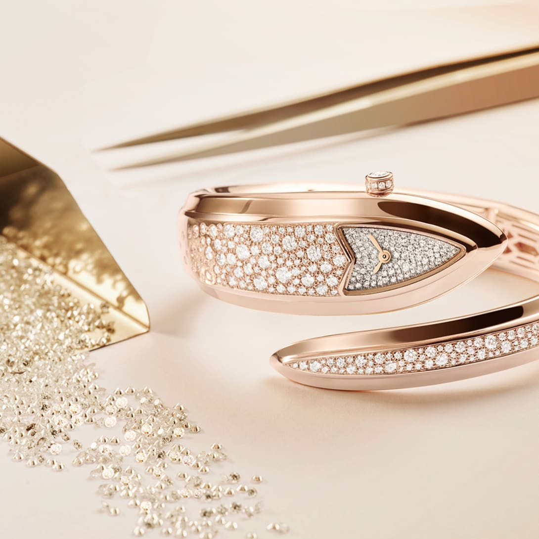 Serpenti Aterna rose gold watch set with diamonds, and tools and diamonds for the gem setting.