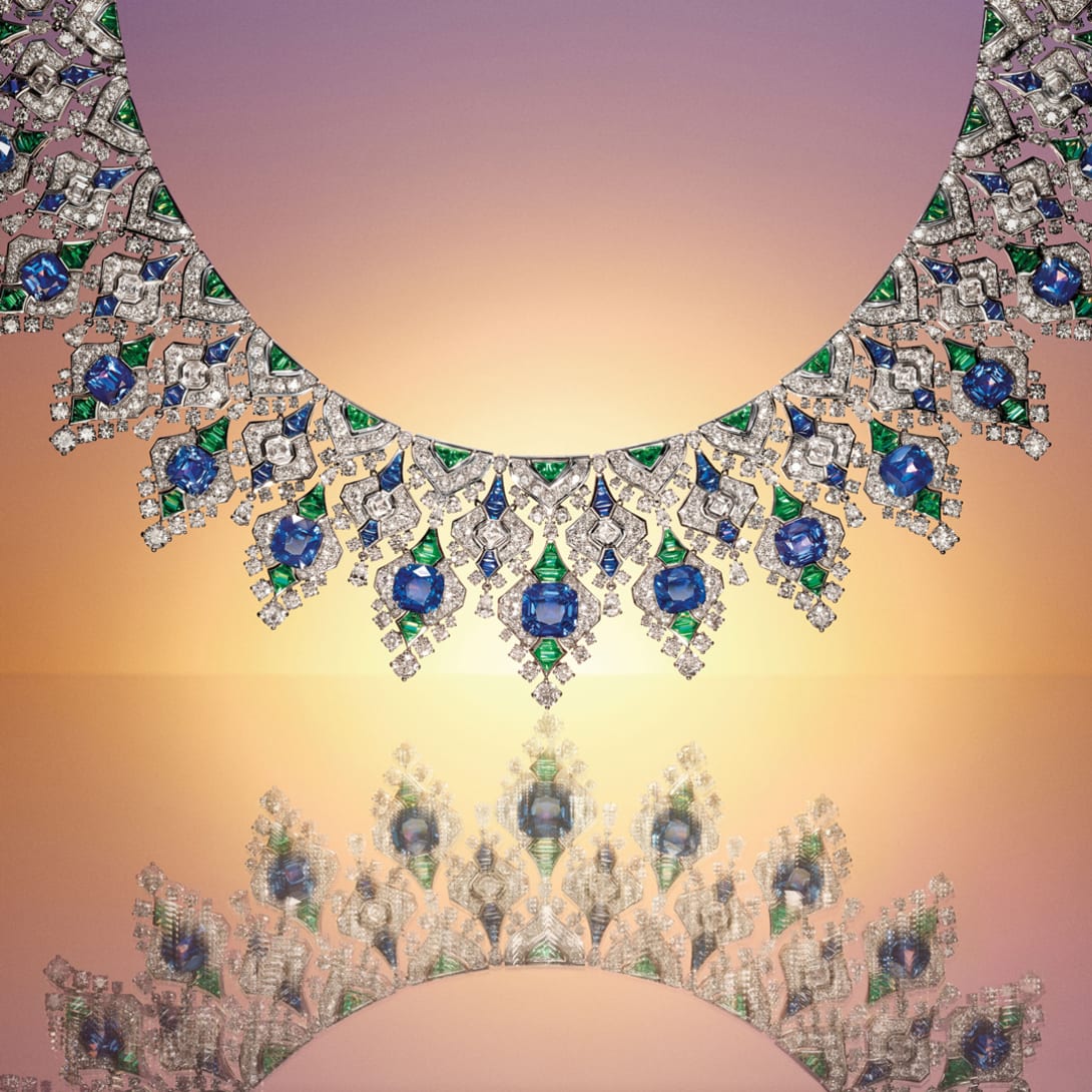 Model wearing The Sapphire Brocade High Jewellery necklace with cushion sapphires, emeralds and diamonds, close-up.