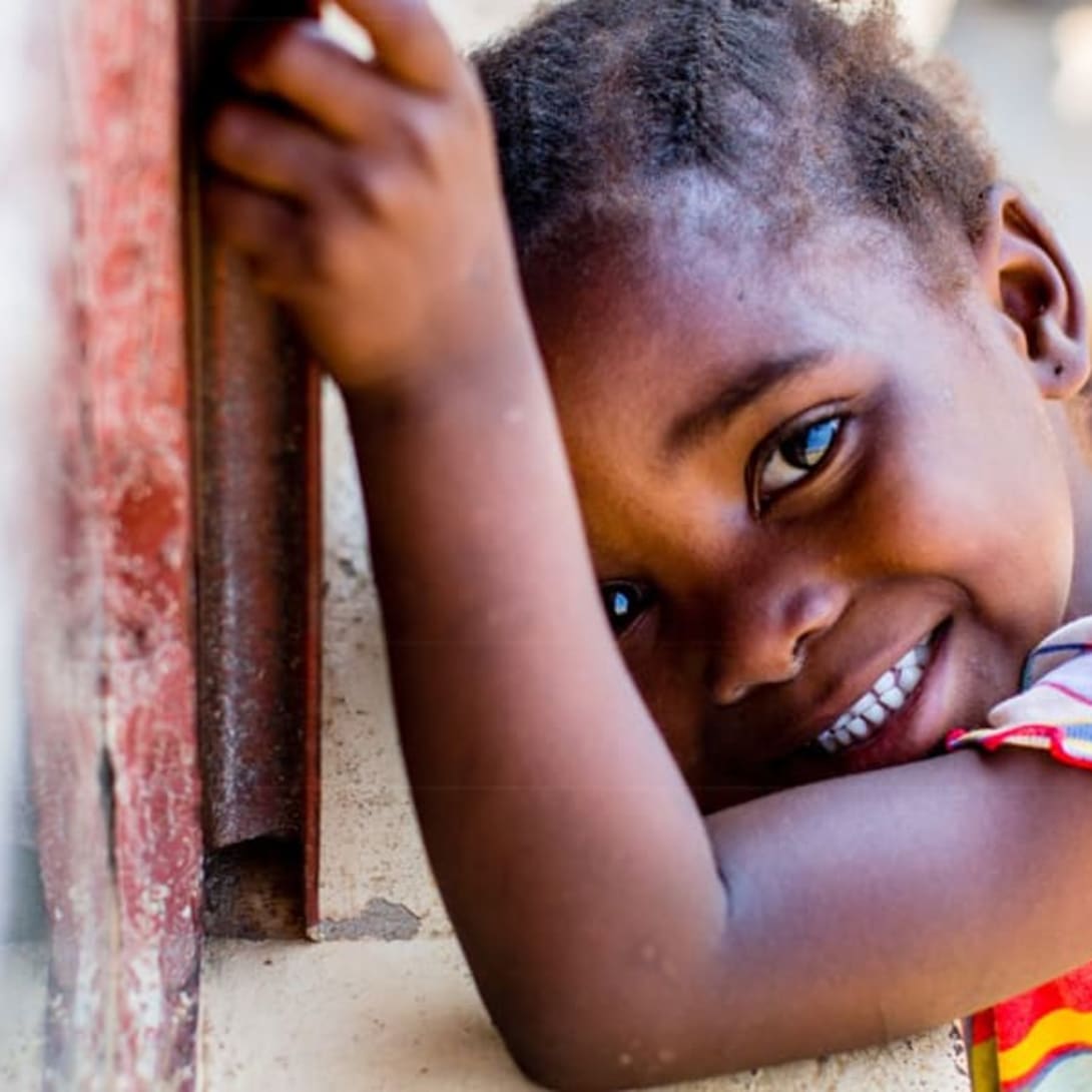 Young child smiling looking at the camera (picture from a Save The Children campaign