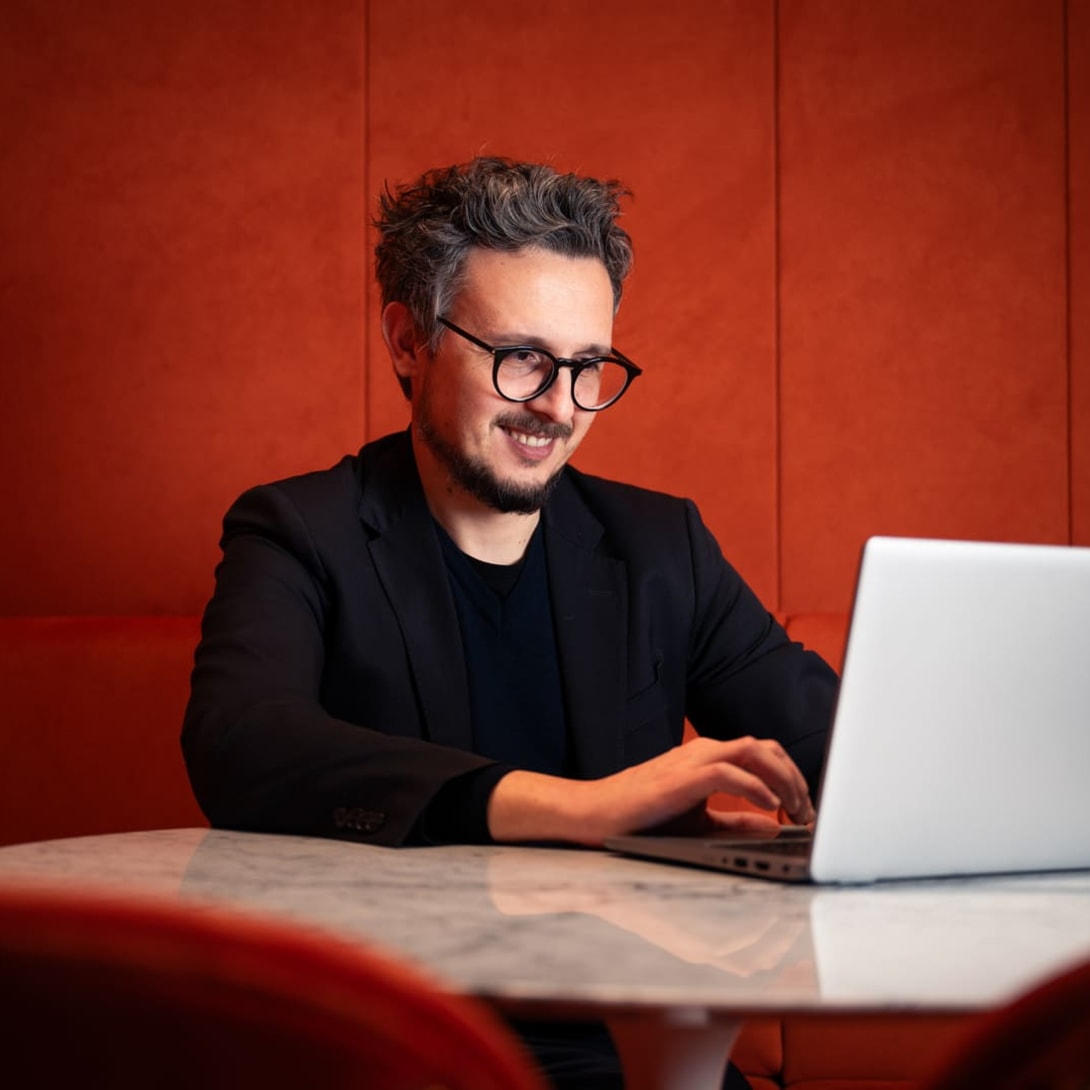 Nicola, Data Domain Manager na Bvlgari, sorri enquanto trabalha em seu computador