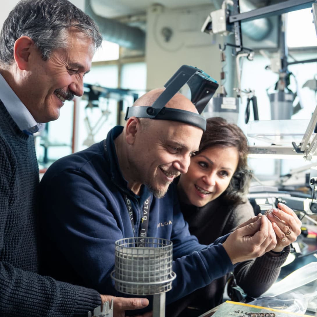 Massimo, High Jewelry Production Senior Director, supervises two colleagues work at their Goldsmith's workbench
