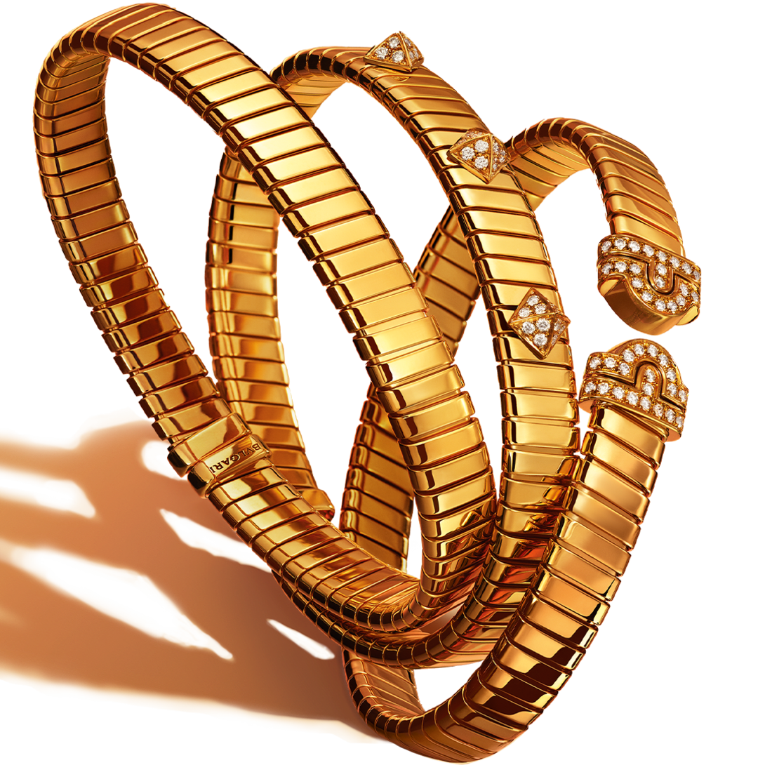 Three Bvlgari Tubogas yellow gold bracelets, plain, with diamond-set studs and Parentesi motif.