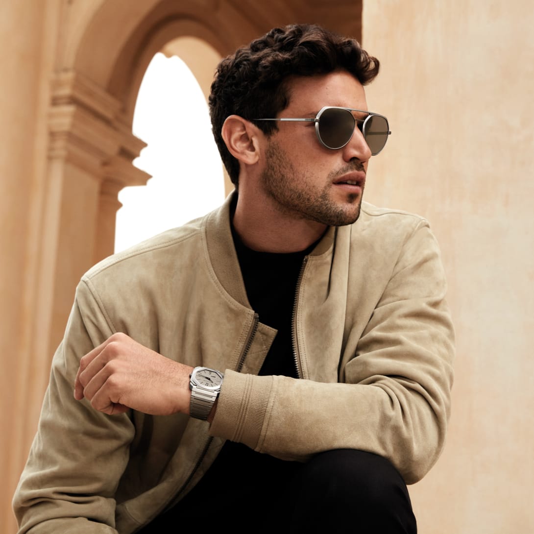 Man wearing Octo Finissimo aviator sunglasses with metallic frame, Roman terrace backdrop.