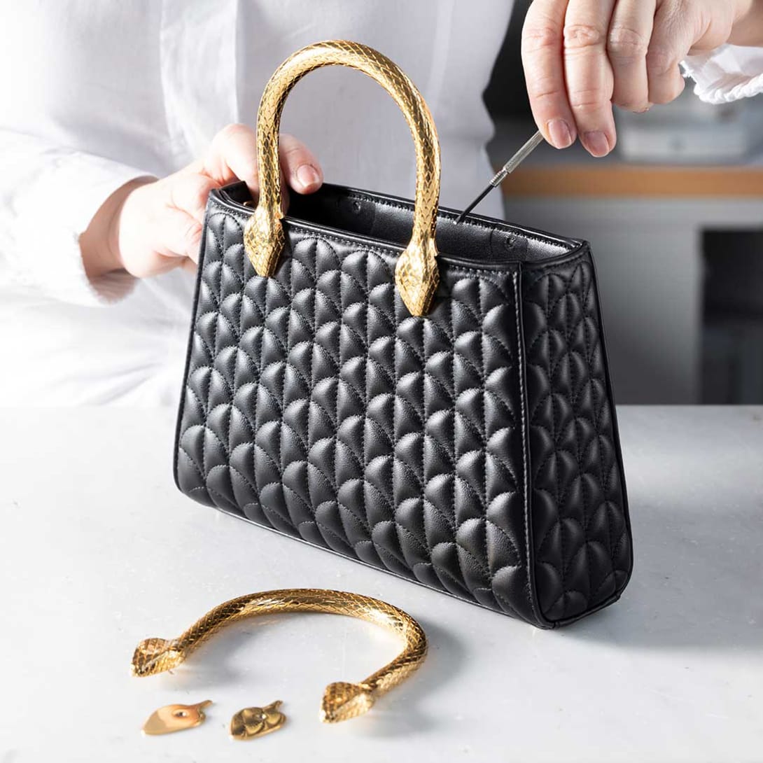 Sewing of a green crocodile panel during the making of a Bulgari handbag.