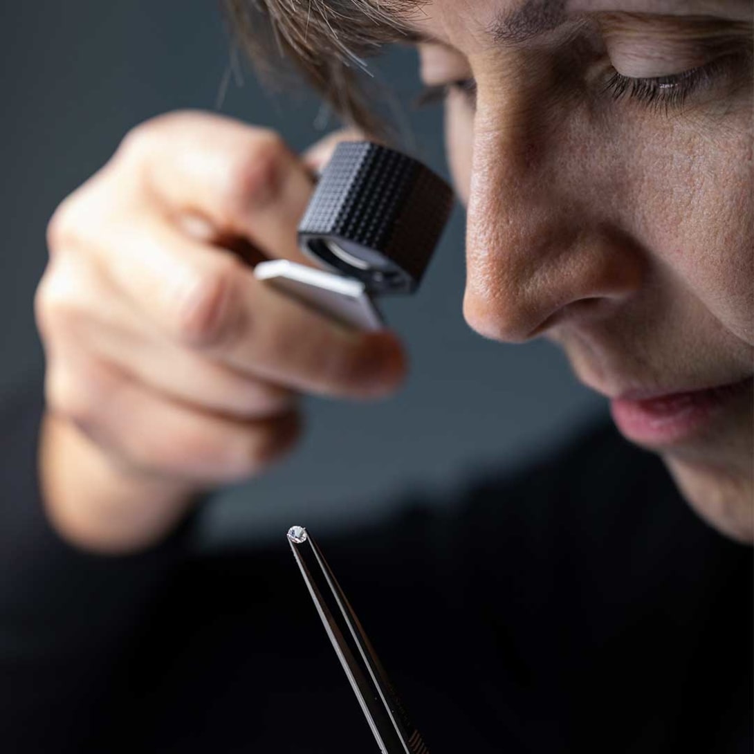 Setting of a diamond on the B.zero1 Rock white gold pendant, black background with diamonds.