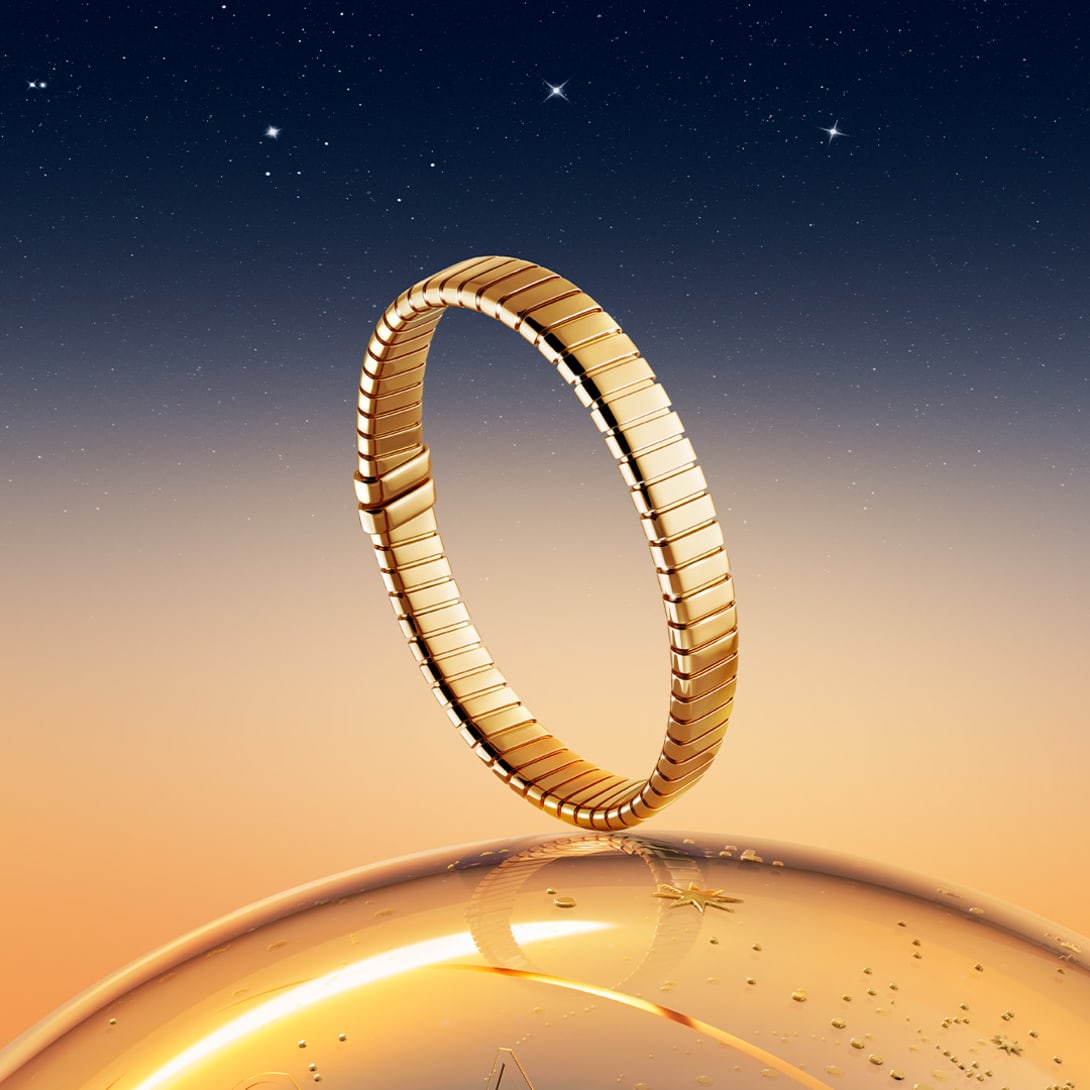 Bvlgari Tubogas yellow gold bracelet in front of a starry night sky, Holiday Season campaign.