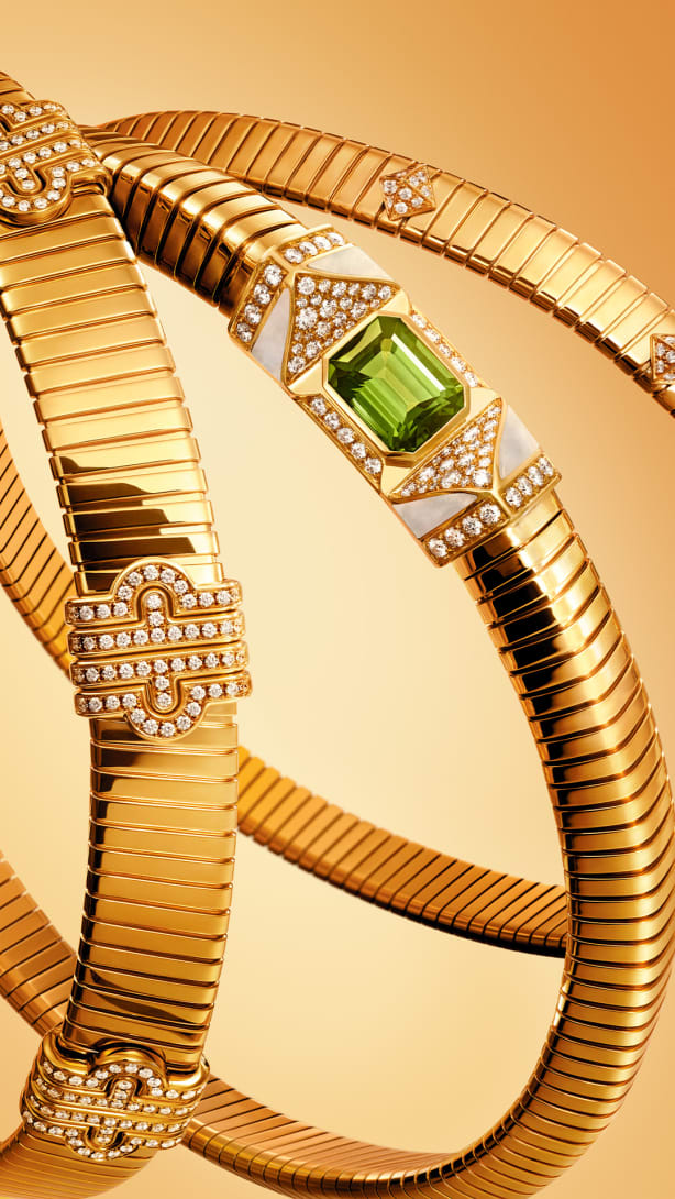 Bvlgari Tubogas yellow gold jewels set with diamonds, a green tourmaline and mother-of-pearl, close up.