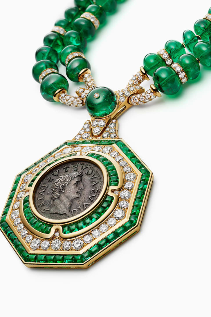 The Augustus Aeternus Emerald Monete High Jewellery sautoir with a rare bronze coin, emeralds and diamonds, close-up.