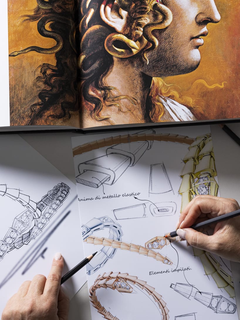 Bvlgari jewellery sketches with a designer’s hand and artwork inspiration in the background.