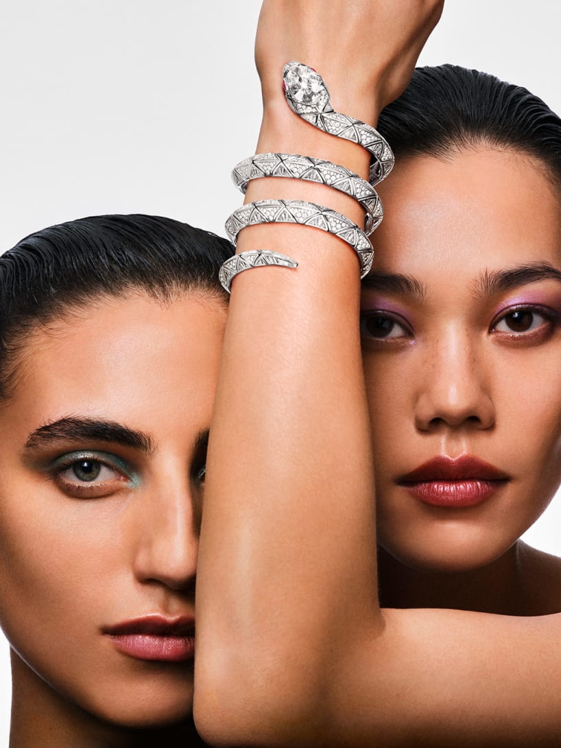 Two models, one wearing a High Jewellery Serpenti double-spiral white gold diamond bracelet, close up.