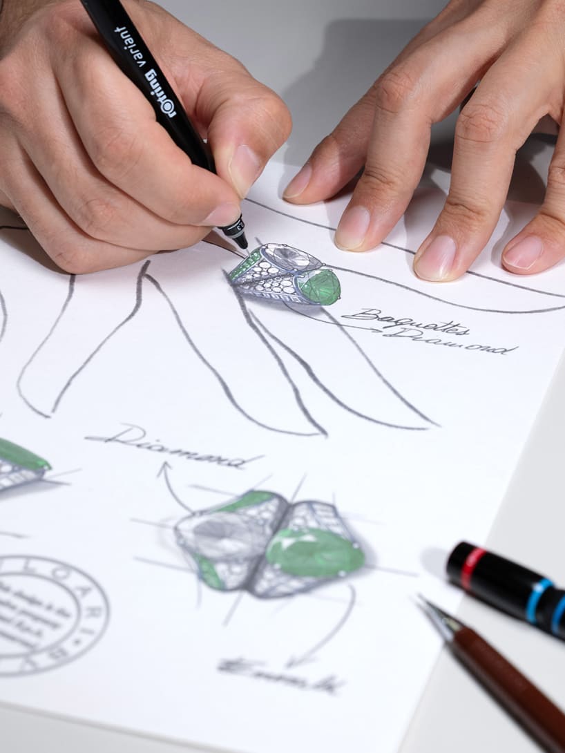 Hands painting the Incontro Segreto High Jewellery toi et moi ring in white gold with diamond and emerald.
