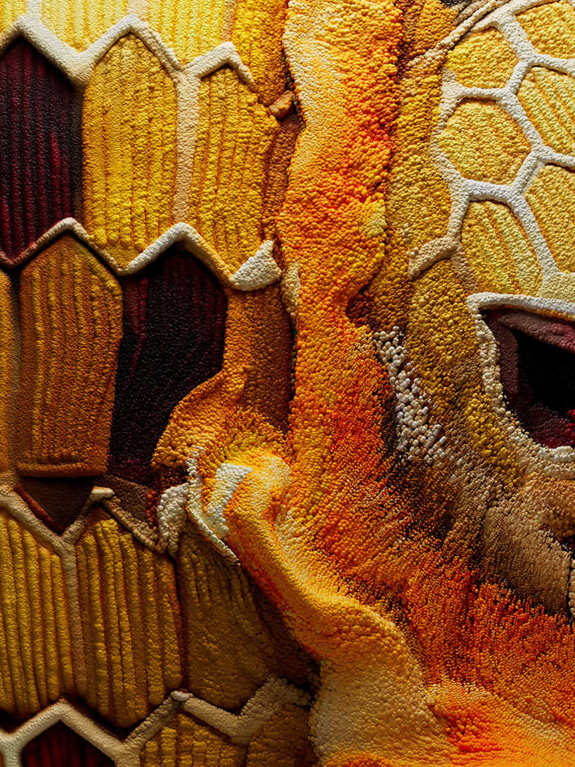 Serpenti Heritage bracelet in yellow gold with red and yellow enamel and red gemstone eyes, close up.