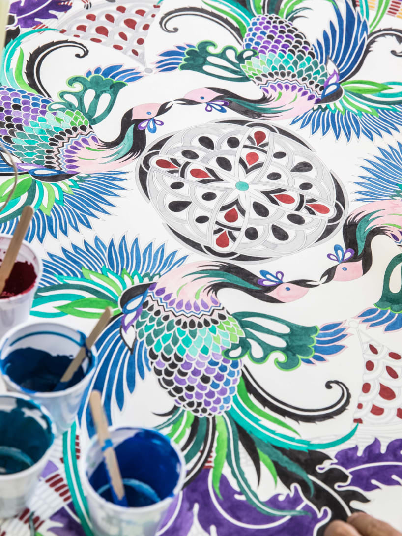 Hand paints a drawing of a Bvlgari Serpenti bag.