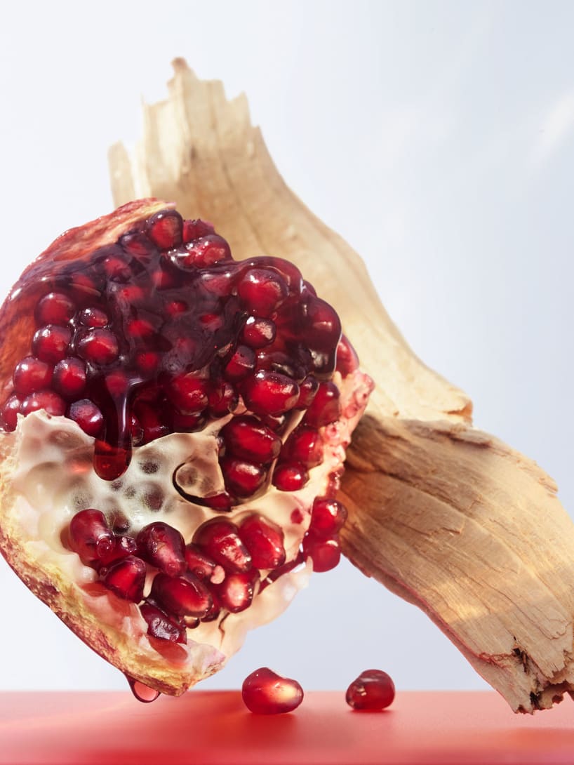 Pomegranate and cedar wood, the base notes of the Omnia Coral fragrance, creative shot.