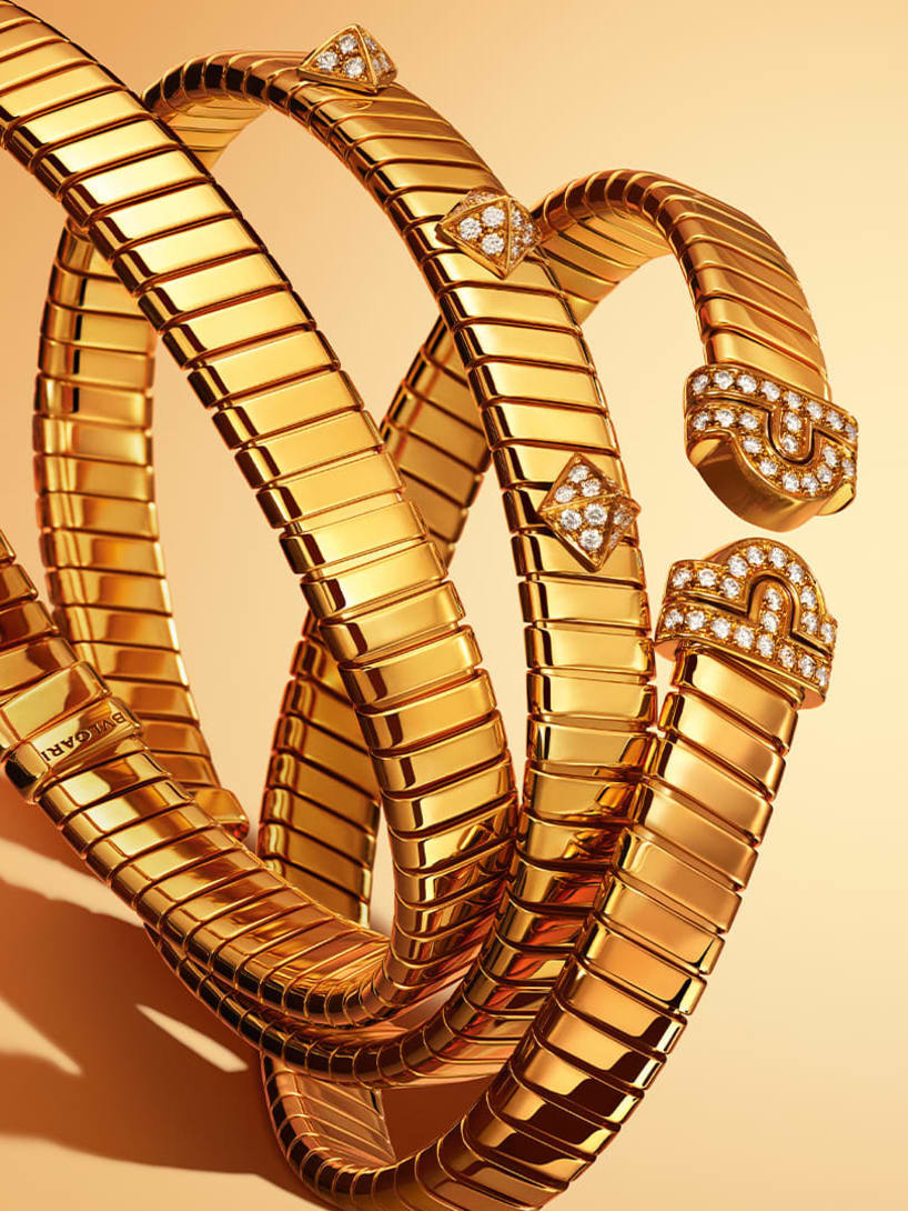 Three Bvlgari Tubogas yellow gold bracelets, plain, with diamond-set studs and Parentesi motif.