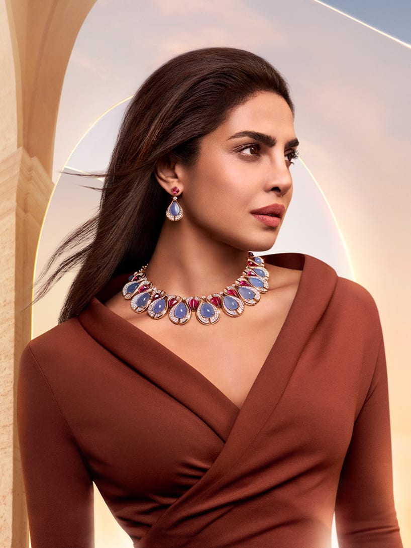 Priyanka Chopra Jonas wearing Bvlgari High Jewellery, dawn sky and Roman architecture in the background.