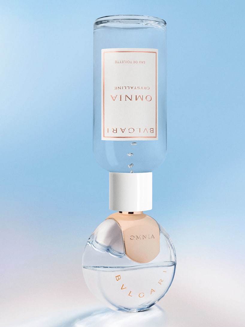 Bottles of the Omnia Crystalline Eau de Toilette and Eau de Parfum, creative shot with ingredients.