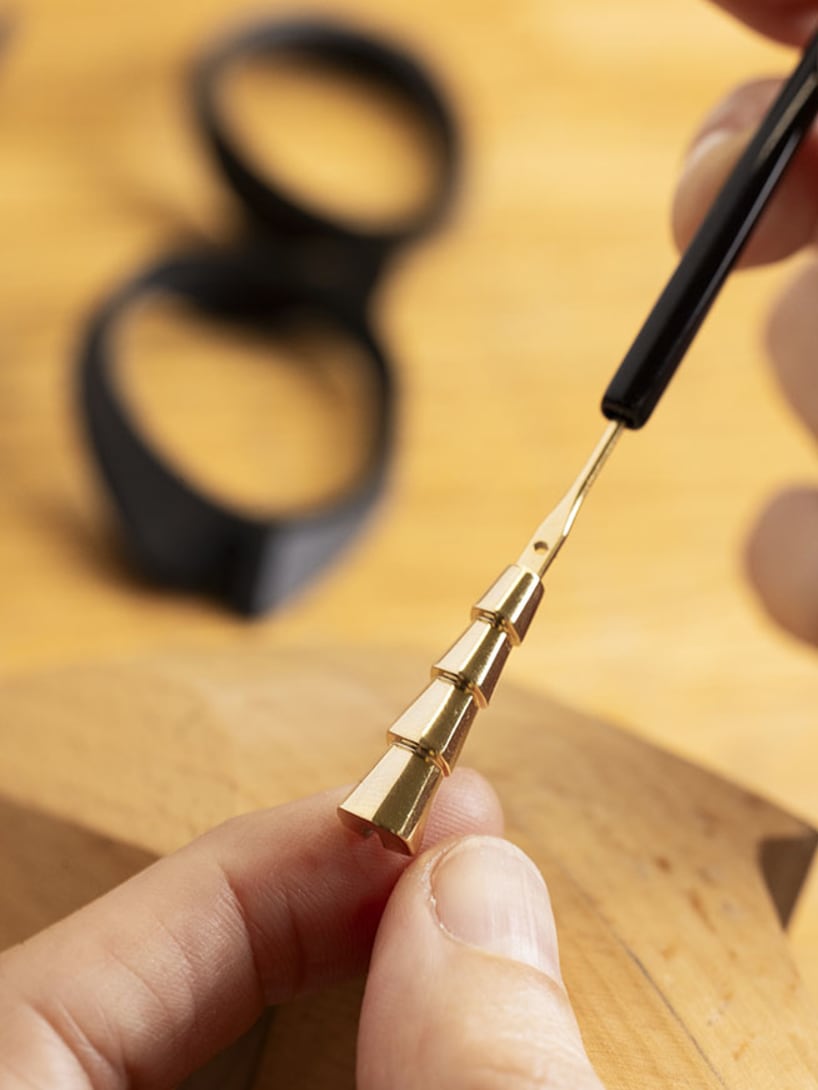 Making of Serpenti Viper snake scale-inspired temples, close up with acetate frame behind.