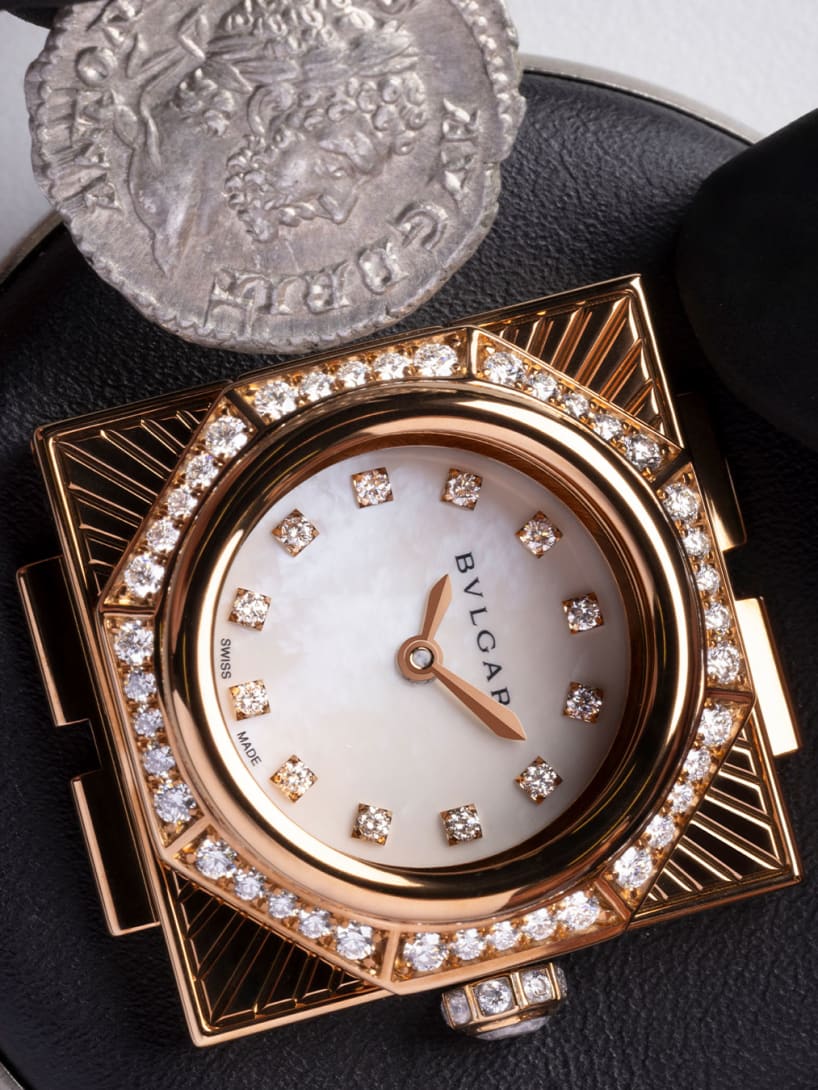 Ancient coin being set on the case cover of the Maglia Milanese Monete secret watch.