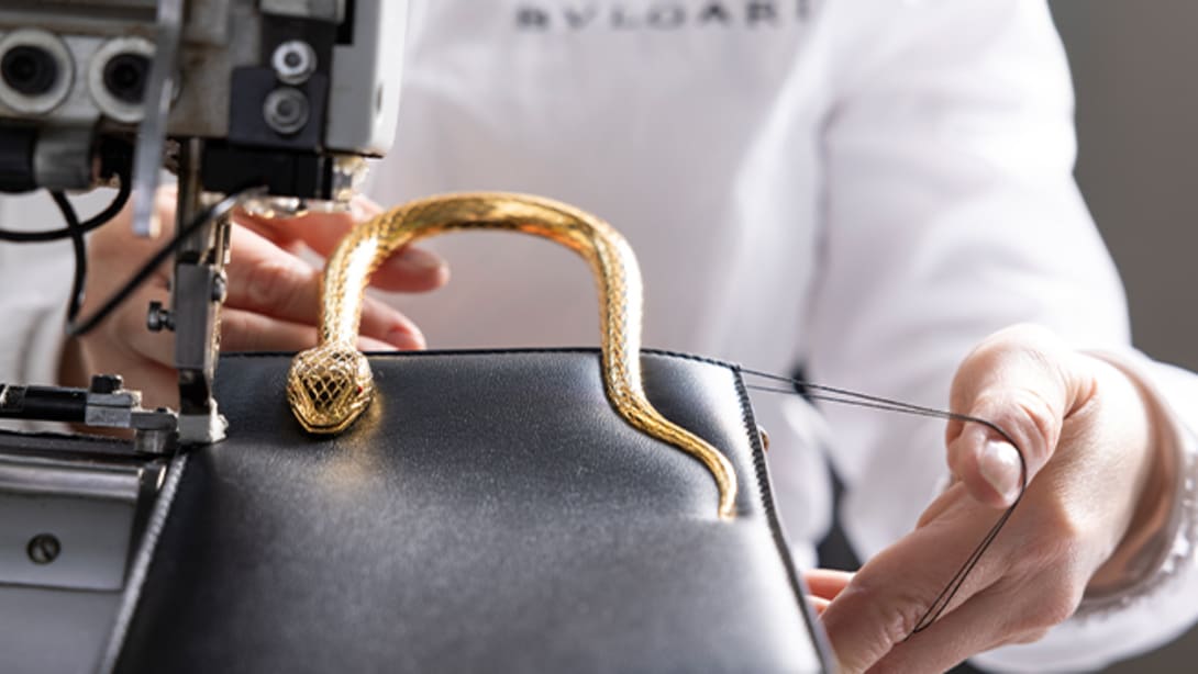 Bulgari artisan assembling the snake body-shaped metallic top handle on the Serpentine vertical tote bag.