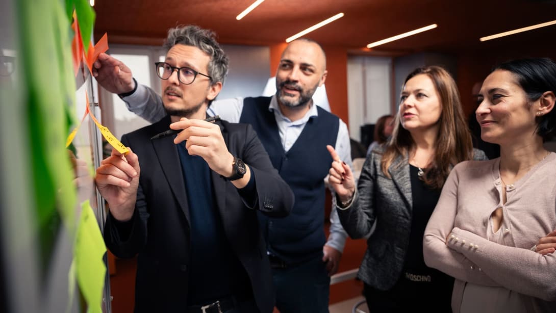 Nicola, responsable de dominio de datos en Bvlgari, trabajando con dos compañeros utilizando pósits