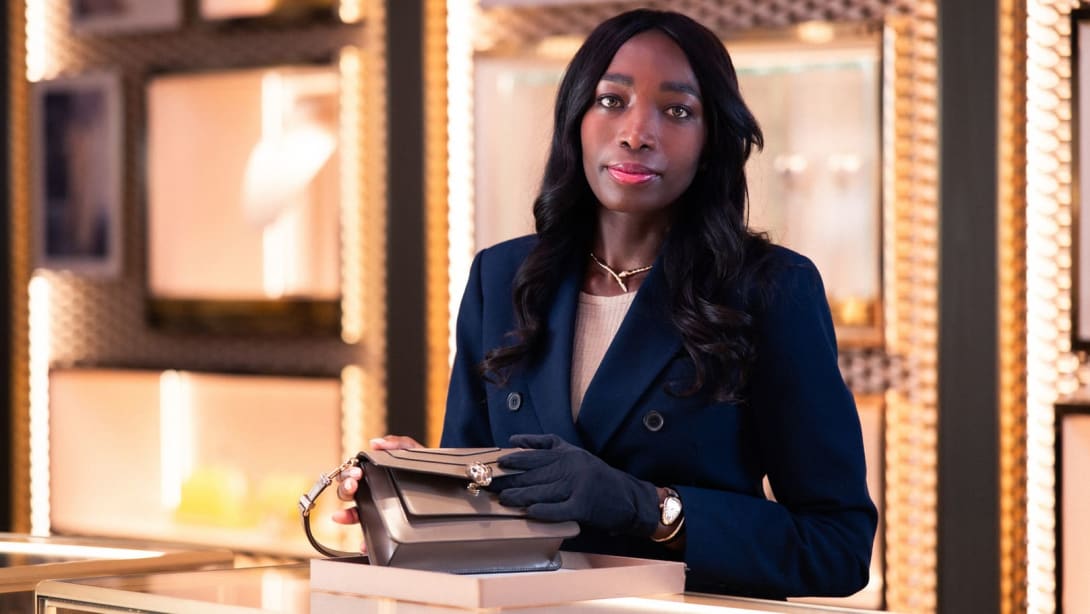 Satù, Store Manager de Bvlgari, cerca del mostrador abriendo un bolso Serpenti