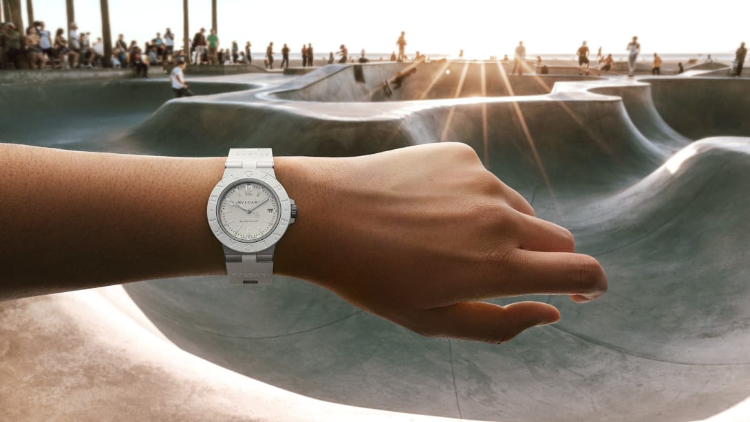 Bvlgari Aluminium White Automatic watch in aluminium and white rubber, seafront with palmtrees in the back.