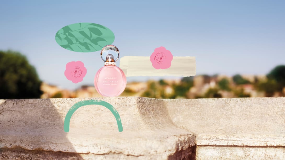 Rose Goldea Blossom Delight Eau de Toilette bottle with Roman backdrop, creative shot.