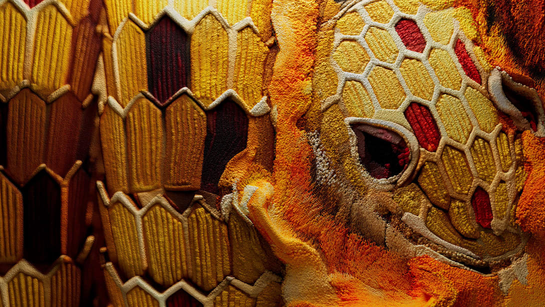 Serpenti Heritage bracelet in yellow gold with red and yellow enamel and red gemstone eyes, close up.