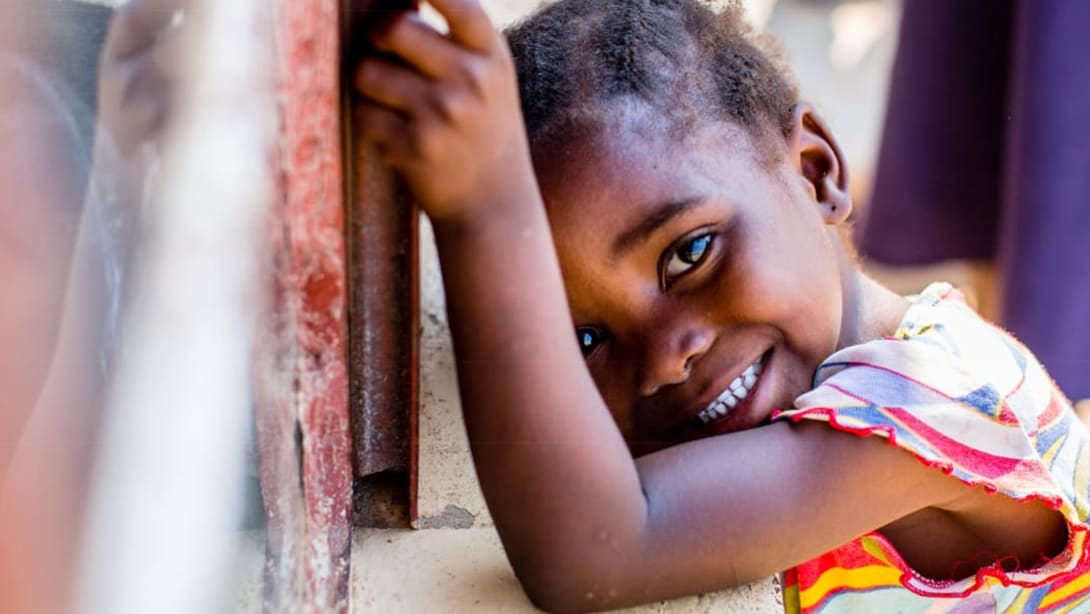 Young child smiling looking at the camera (picture from a Save The Children campaign