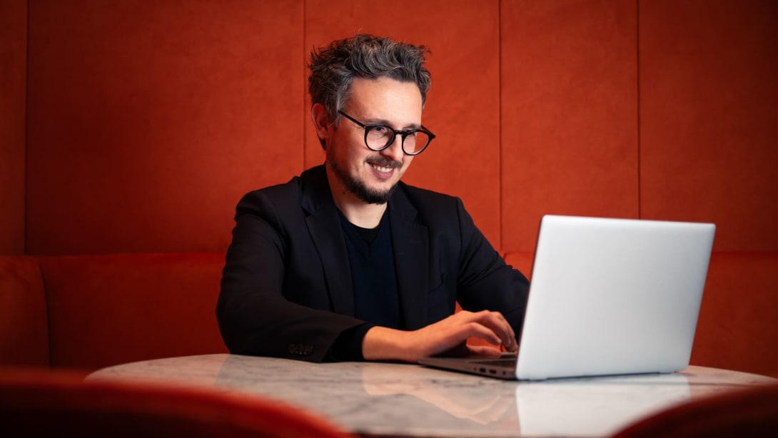 Nicola, Data Domain Manager na Bvlgari, sorri enquanto trabalha em seu computador
