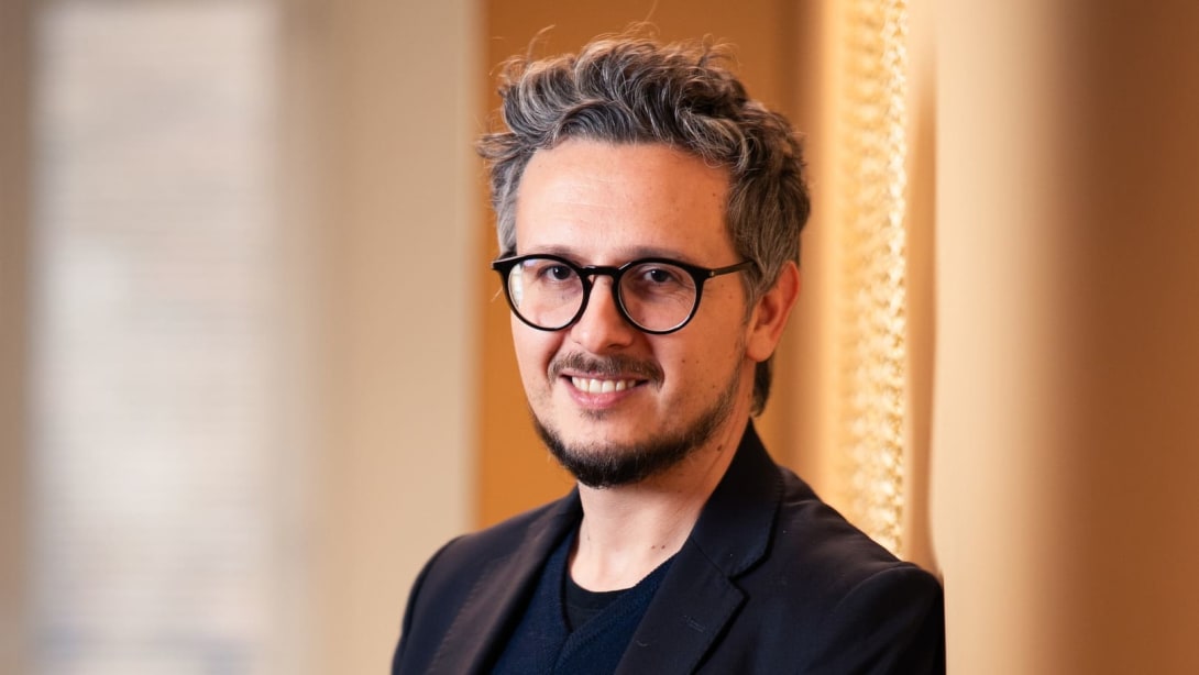Nicola, Data Domain Manager at Bulgari, leans against the wall and smiles
