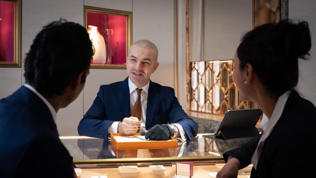Un dipendente Bvlgari mostra un prodotto ai due clienti con cui sta parlando