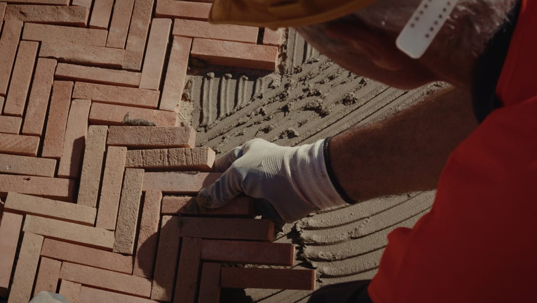 Craftsman assembling handmade tiles during the restoration of the Bvlgari Hotel Roma, close-up.