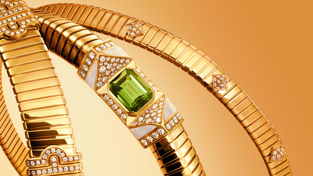 Bvlgari Tubogas yellow gold jewels set with diamonds, a green tourmaline and mother-of-pearl, close up.