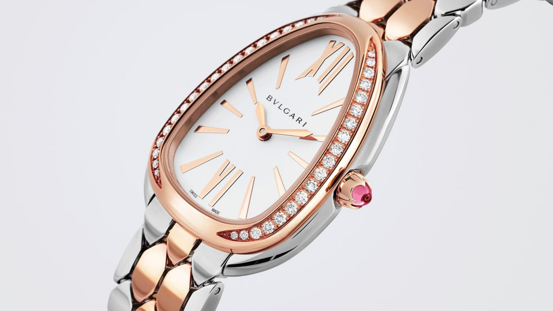 Serpenti Seduttori rose gold and steel watch with diamonds on the bezel and white dial, close-up.