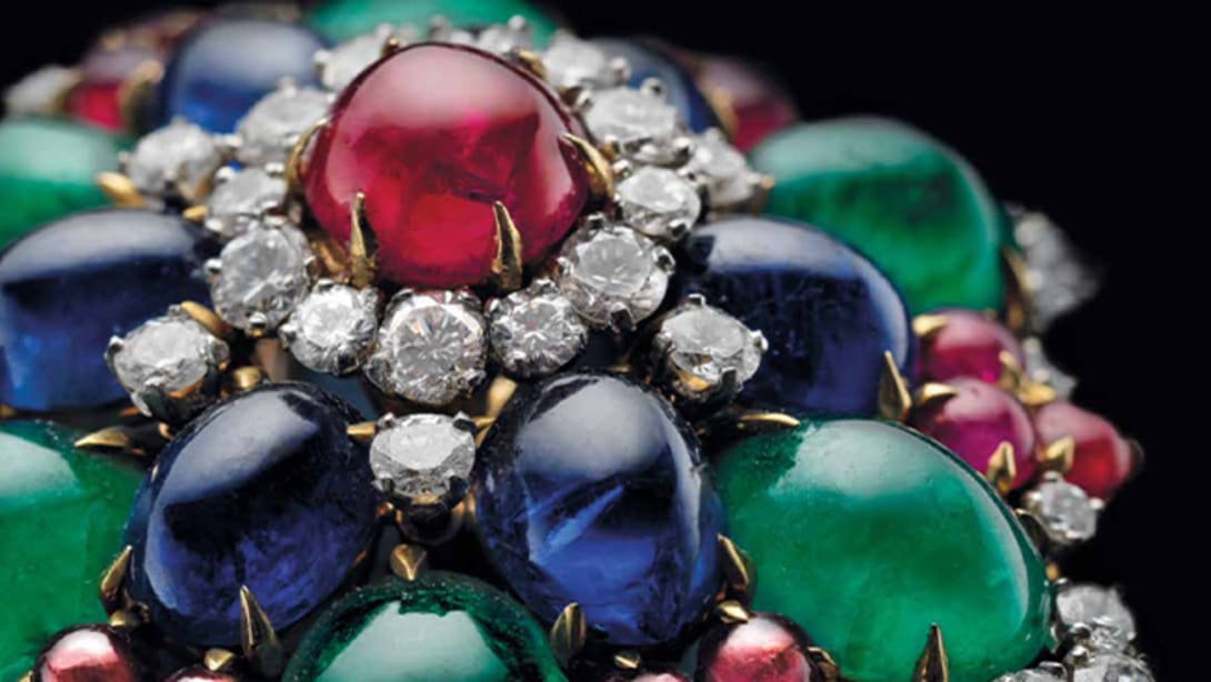 Bulgari heritage flower brooch with cabochon rubies, emeralds and sapphires, and diamonds, close up.