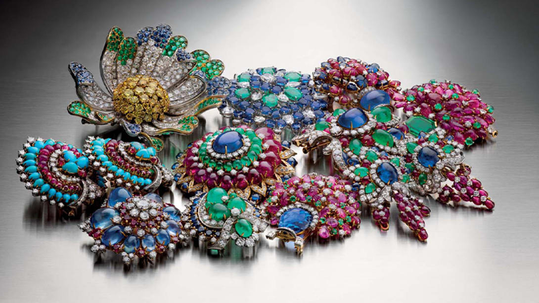 Multiple Bulgari Heritage brooches and earrings with cabochon cut coloured gemstones, creative shot.