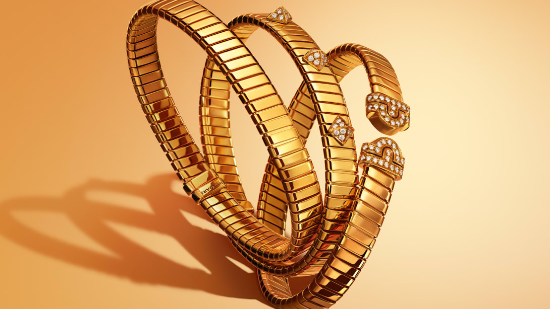 Three Bvlgari Tubogas yellow gold bracelets, plain, with diamond-set studs and Parentesi motif.