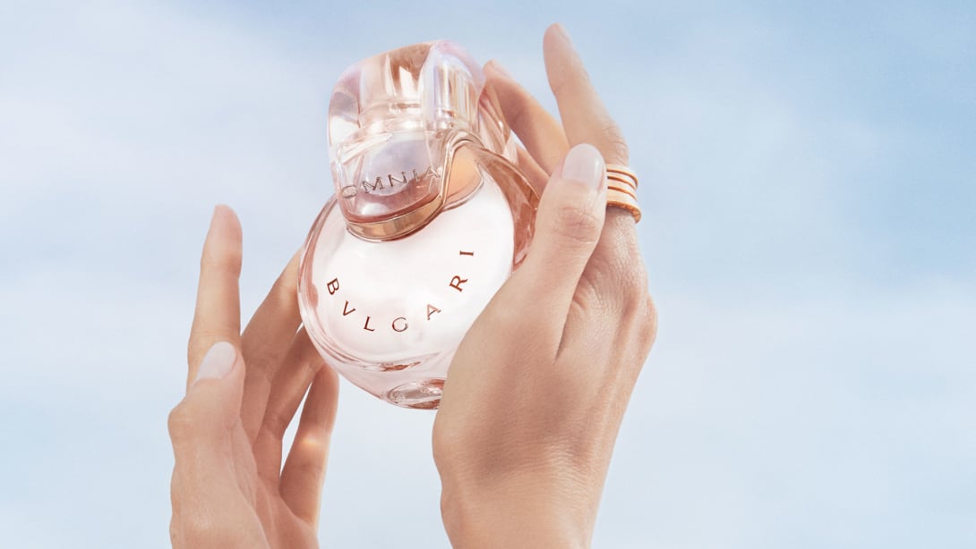 Powder pink transparent bottle of the Omnia Crystalline Eau de Parfum, blue sky in the background