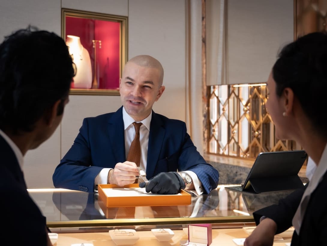 Un dipendente Bvlgari mostra un prodotto ai due clienti con cui sta parlando