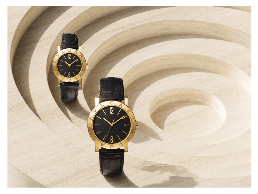 Bulgari Bulgari watches with 18 kt yellow gold case and black leather bracelet. Abstract architecture in the background.