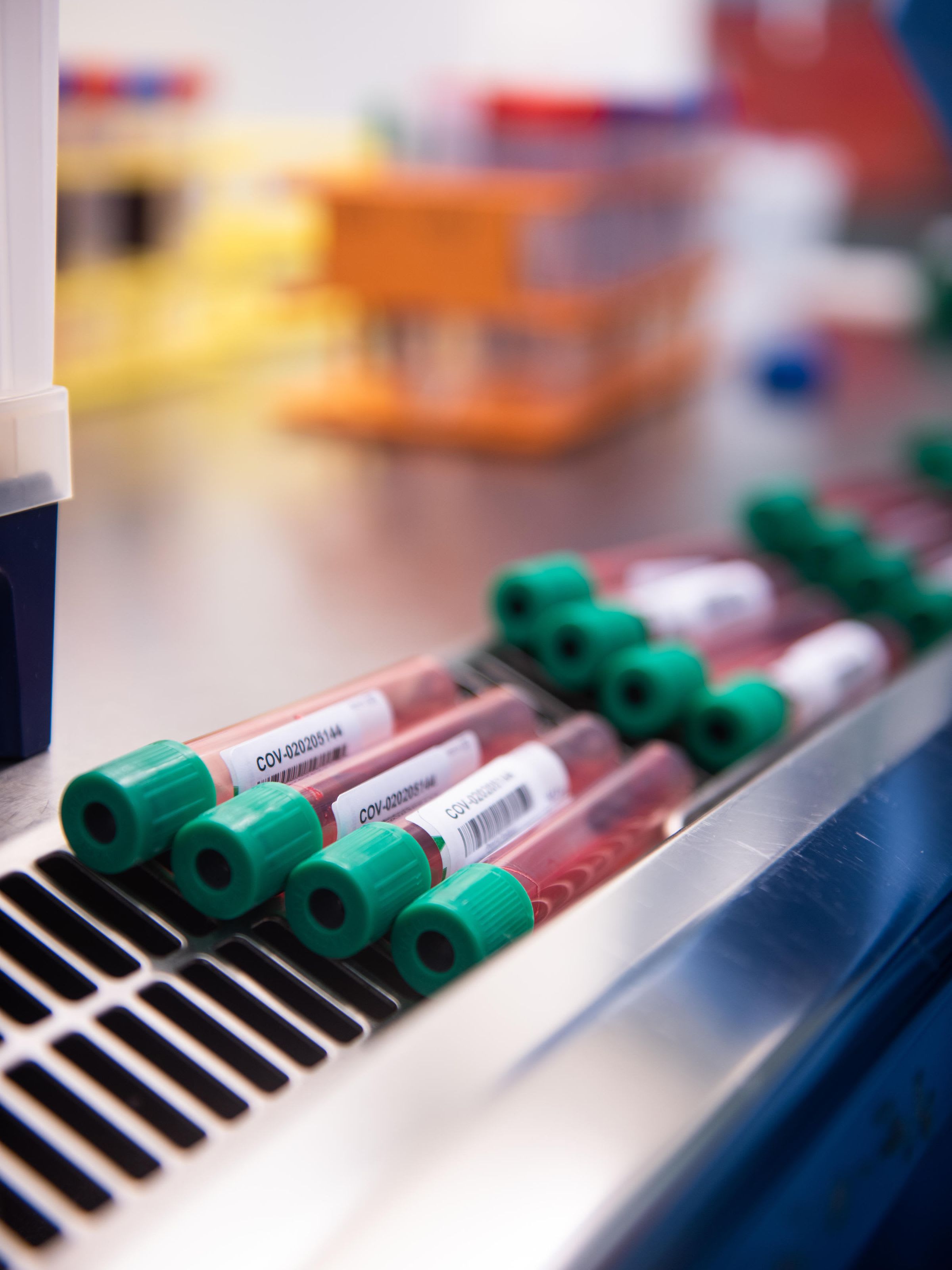 Healthcare professional analyzing test tubes.