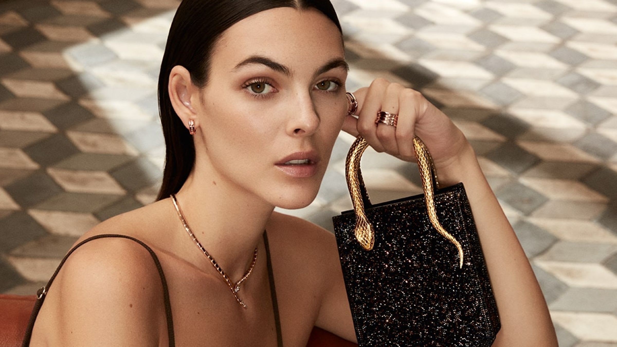 Vittoria Ceretti holding a black Serpentine Tote Crystal Sparkle bag with snake handle, Roman interior.