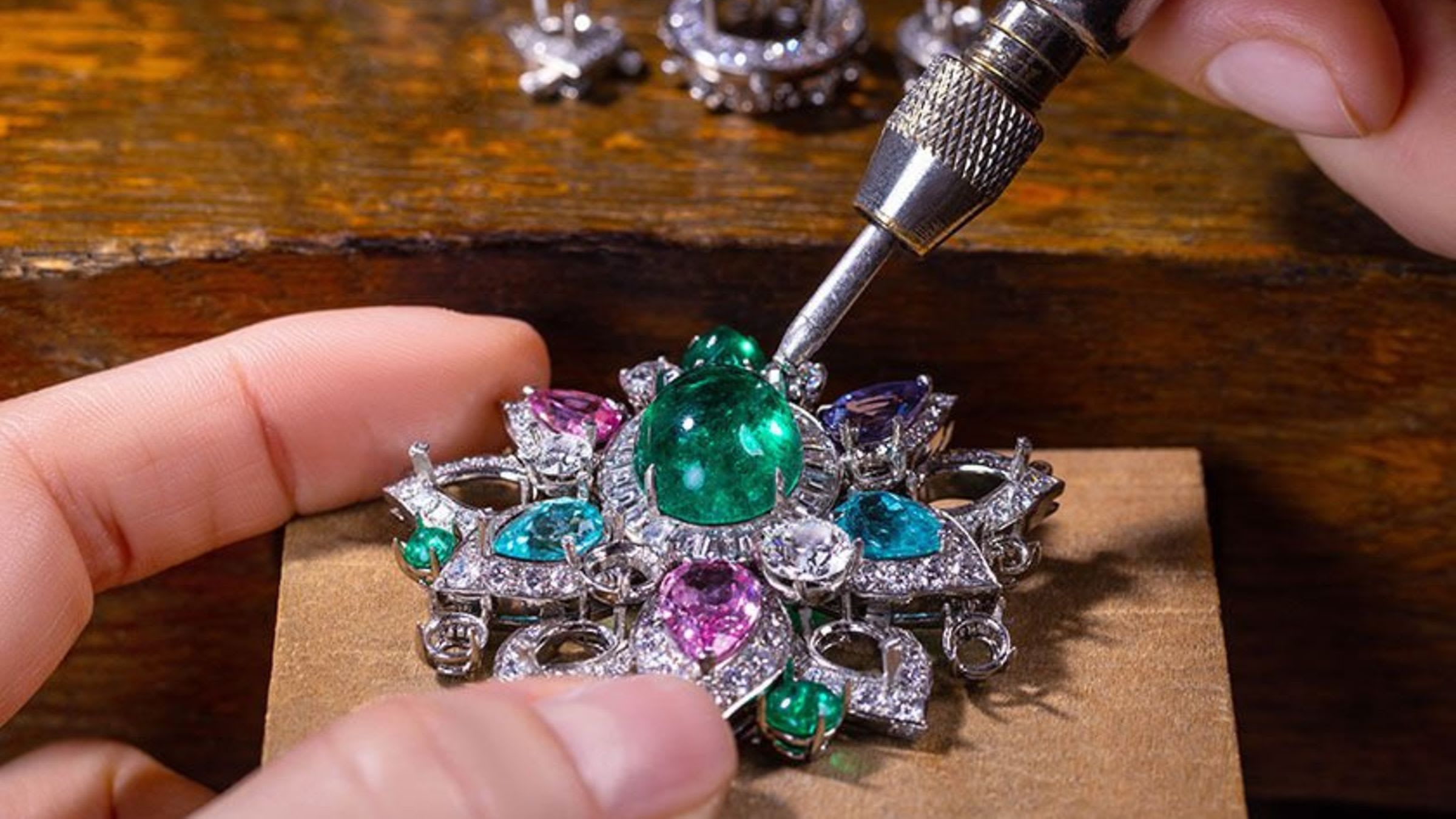 Making of the flower of the Blossoming Beauty necklace with coloured gemstones, close up of the hands.