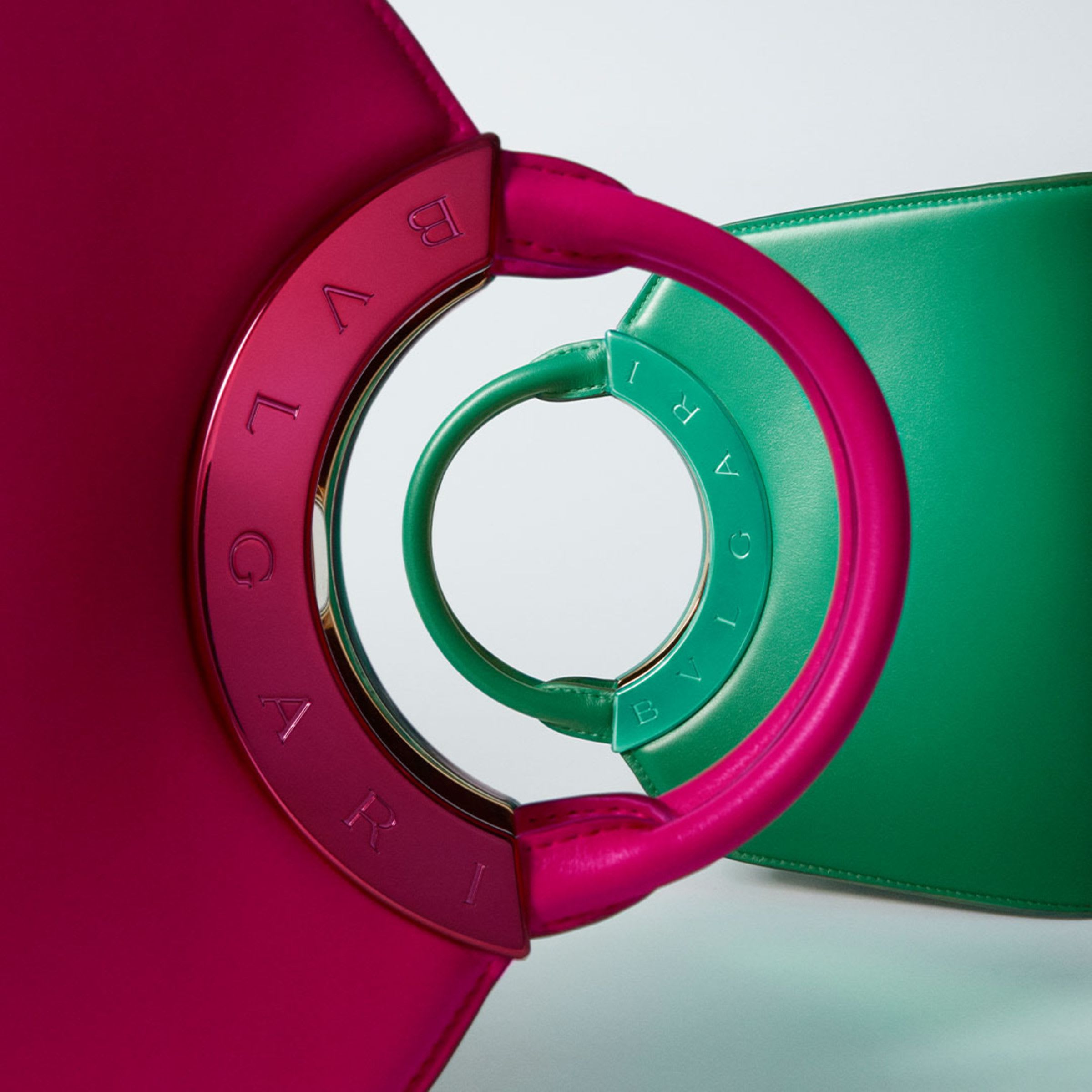 Creative shot of two giant Bulgari Roma handbags positioned vertically one in front of the other.
